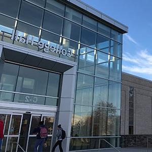 Front of College Hall with students walking into the building